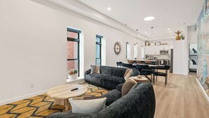 Un soggiorno moderno con divano, tavolino e zona pranzo con tavolo e sedie.
