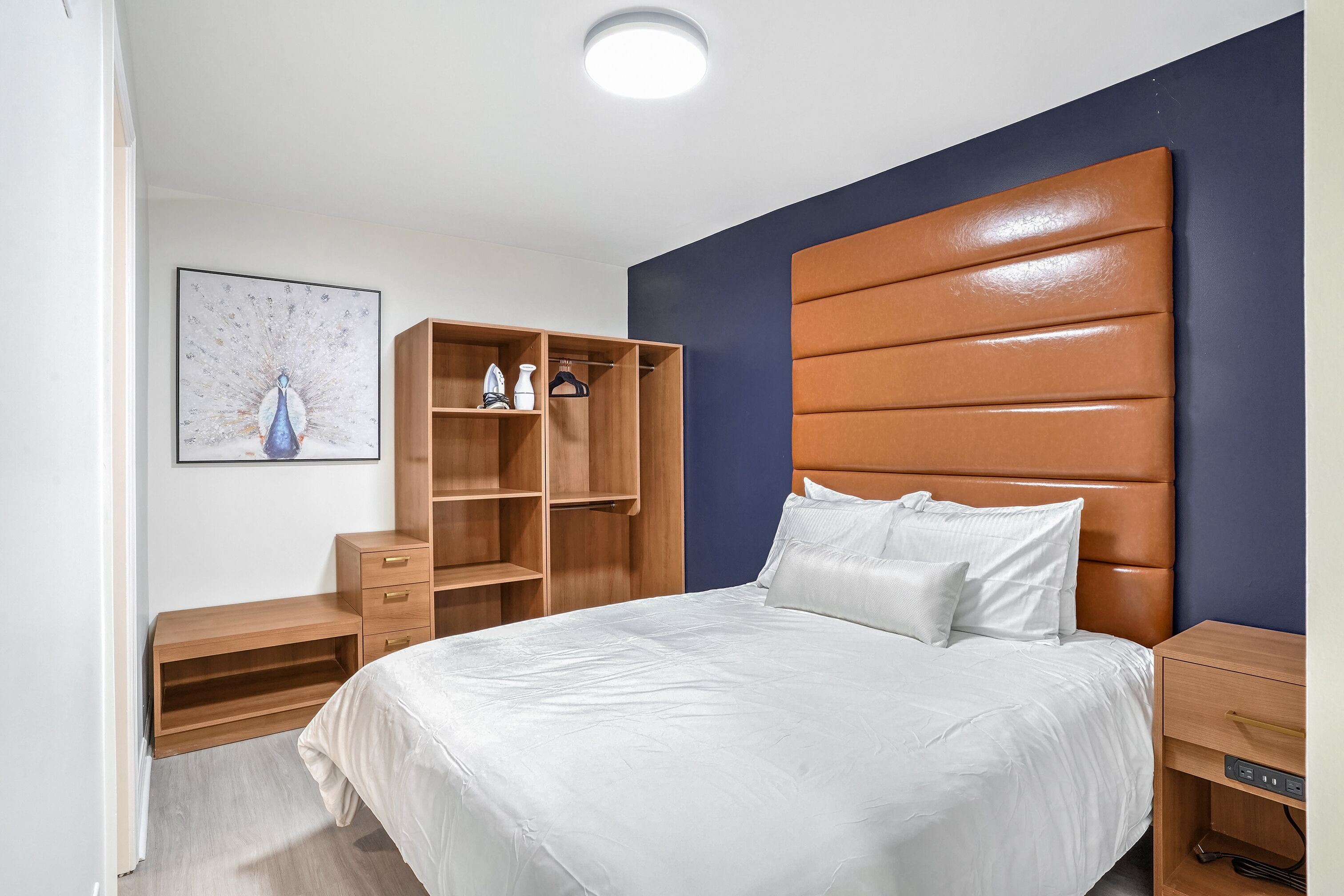 Una camera da letto con un letto grande, un'armadio in legno e una mensola a parete.
