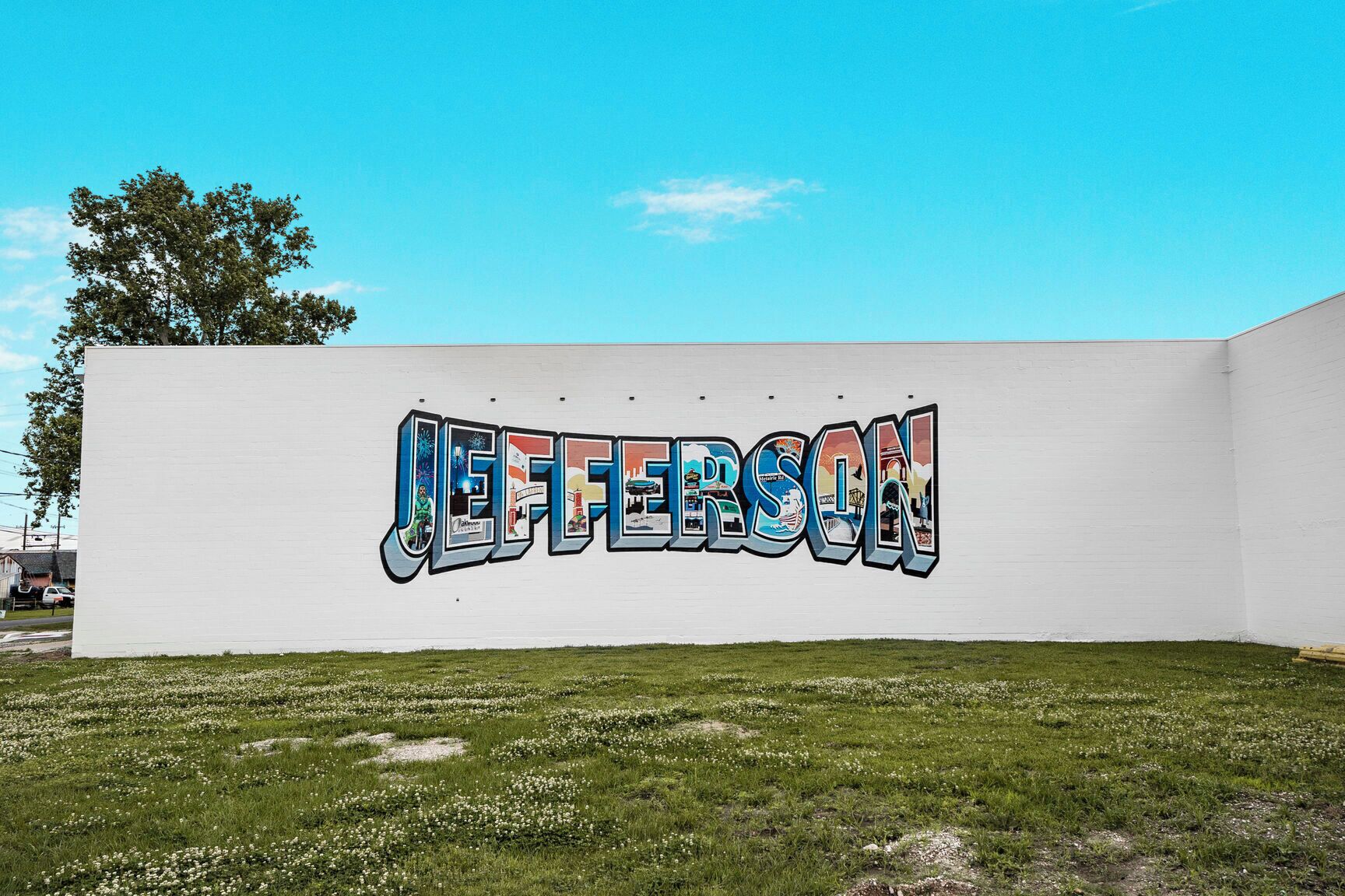 A white wall with the word "JEFFERSON" painted in colorful graffiti.