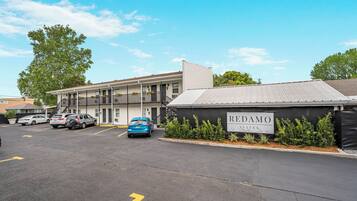 REDAMO SUITES offers a two-story building with a flat roof and a second-floor balcony.