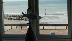 Blick auf den Strand durch ein Fenster, mit einem Schild, auf dem steht: "Der Strand ist, wo mein Herz ist."