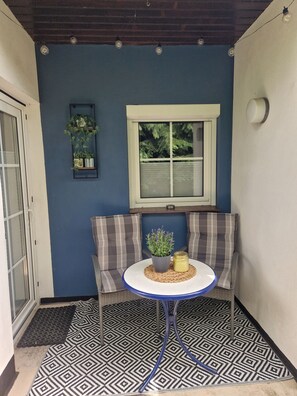 Un coin salon avec une table, un banc et une fenêtre équipée de stores.