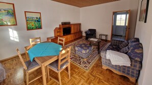 Un salon chaleureux, avec des meubles en bois, un téléviseur et un tapis à motifs.