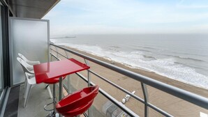 A balcony with a red table and chairs overlooking the beach. - Studio in Blankenberge Near Beach & Pier (Blankenberge)