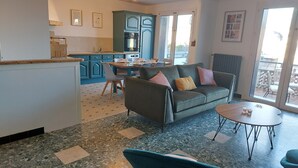 Ein modernes Wohnzimmer mit einer Couch, einem Couchtisch und einem Essbereich mit Stühlen und einem Tisch.