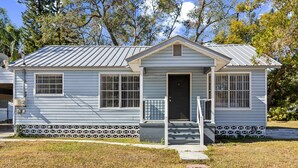 A single-story house with a front porch, a garage, and a small front yard.