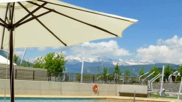 Une piscine avec vue sur les montagnes en arrière-plan.