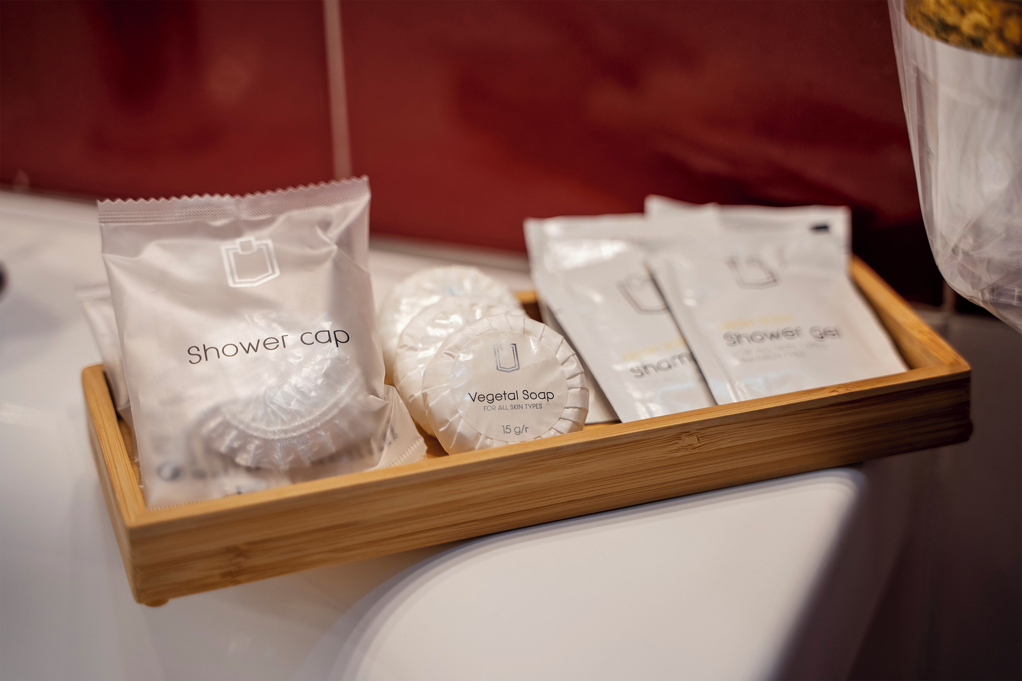 A tray with various shower products including a shower cap and vegetable soap.