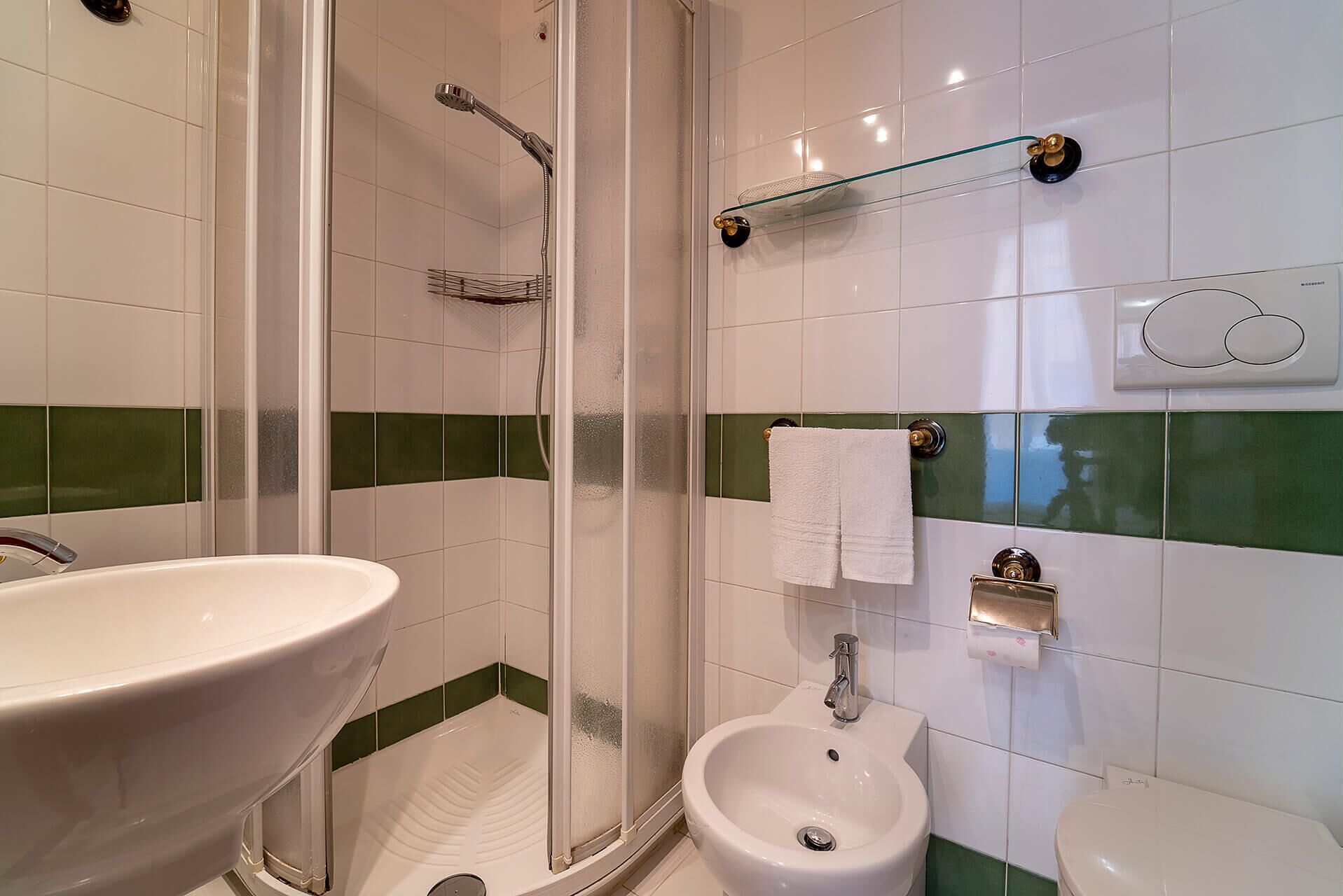 A bathroom with a shower, sink, and toilet.