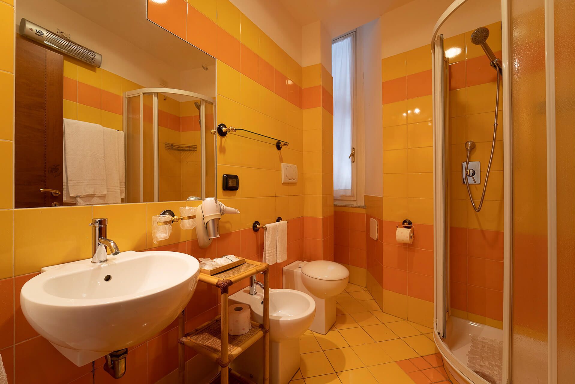 Een badkamer met een groot wastafel, toilet en douche.