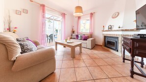 A living room with a sofa, coffee table, and fireplace. - Villa Azzurra (Albufeira)