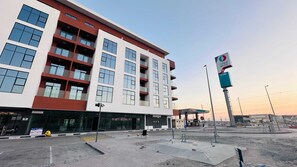 A multi-story building with large windows and balconies, a gas station in the foreground, and a clear sky. - Sunday Sheikh Zayed Road Concord Tower Studio by Belvilla (Dubai)