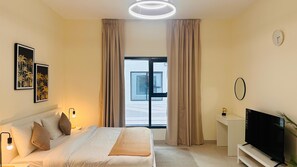 A hotel room with a bed, bedside lamps, a TV, a small table, and a window with curtains. - Sunday Sheikh Zayed Road Concord Tower Studio by Belvilla (Dubai)