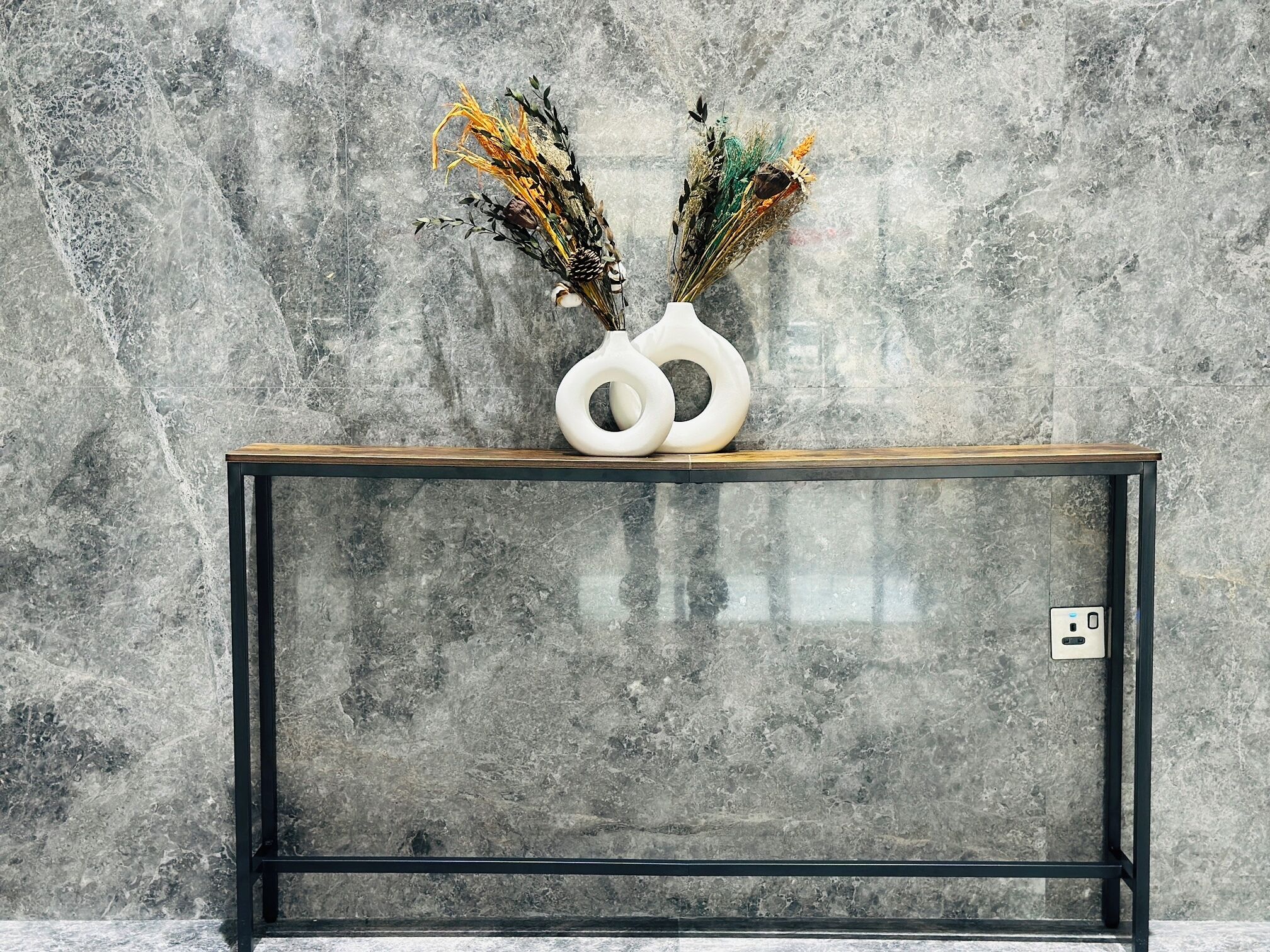A modern console table with a marble wall background.