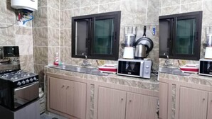 Une cuisine équipée d’une cuisinière, d’un four à micro-ondes et de placards.