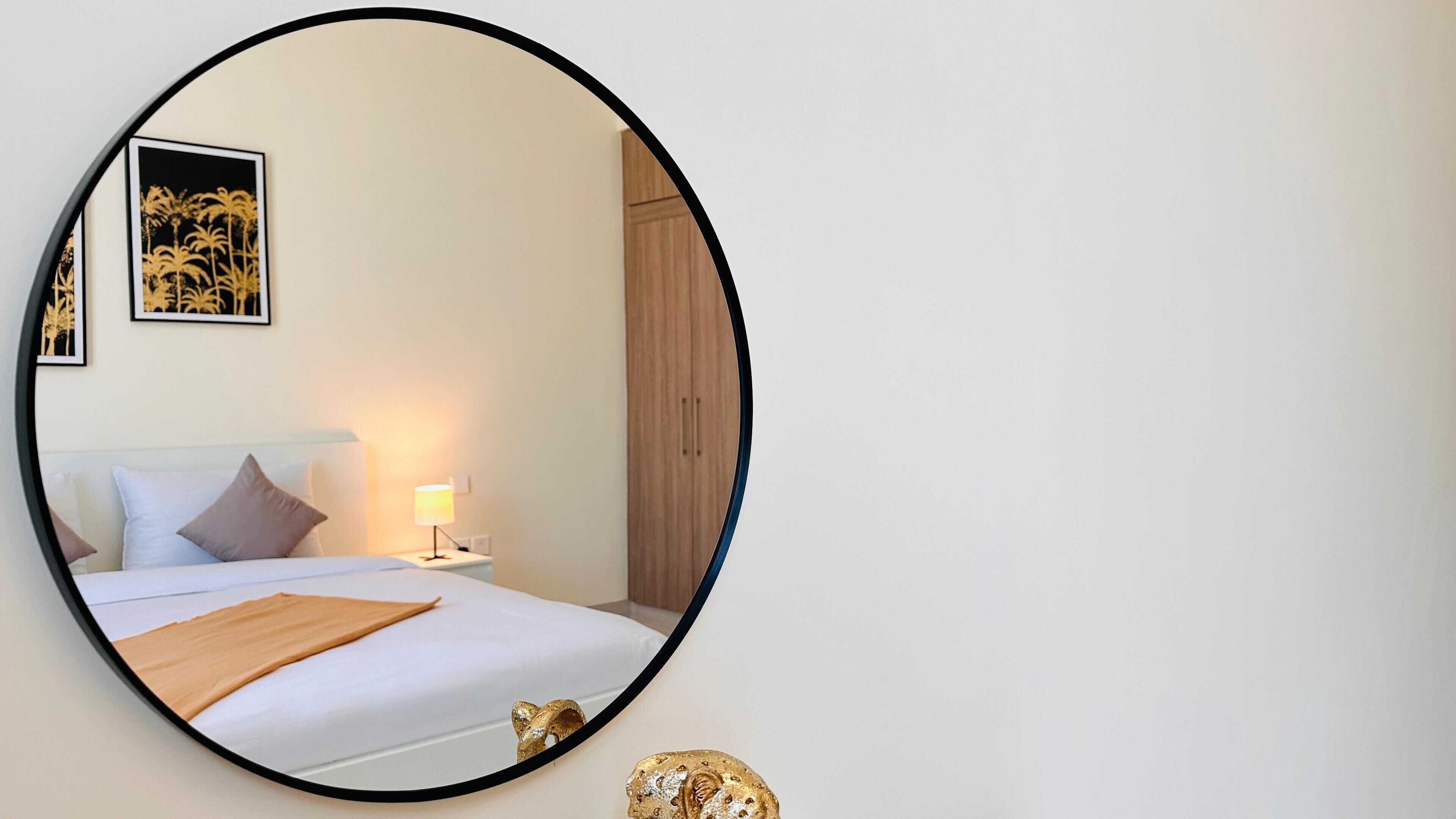 Un dormitorio con una cama, una mesita de noche, una lámpara y un armario de madera.
