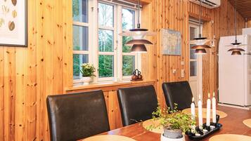 Un interior de madera con una mesa de comedor, sillas, un mapa y un equipo de aire acondicionado.
