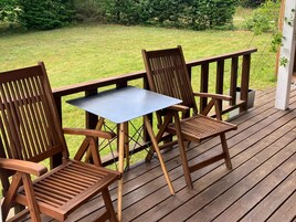 Una terraza de madera con una mesa y dos sillas.