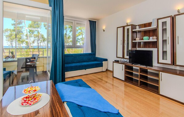 A modern living room with a sofa, TV, and wooden cabinets.