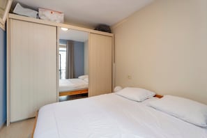 Une chambre à coucher avec un lit, une armoire et un miroir.