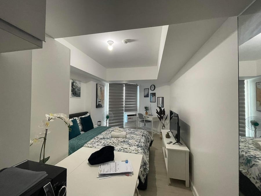 Un dormitorio moderno con cama, mesita de noche y escritorio con silla.