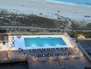 A pool area with lounge chairs and a swimming pool.