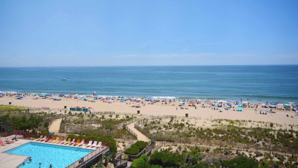 Une plage avec une piscine, une étendue de sable et une vue sur l’océan.