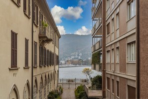A narrow alleyway between buildings with a river and mountains in the background. - The Printers Home 2 in Como (Como)