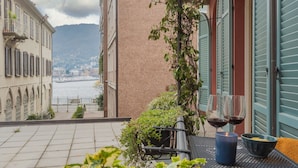 A terrace with a view of the sea, a table with two glasses of red wine, and a candle. - The Printers Home 2 in Como (Como)