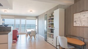 Una cucina moderna con zona pranzo, ampie finestre e vista mare.