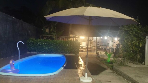 Ein Schwimmbecken mit einer Wassersäule, umgeben von einer gefliesten Terrasse.