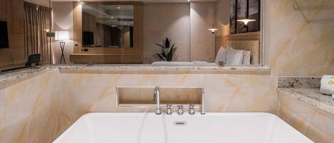 A modern bathroom with a freestanding bathtub, a large mirror, and a vanity with a sink.