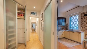 A modern kitchen with a window, wooden flooring, and a view of the outside. - HouSmart Treves 2 (Bologna)