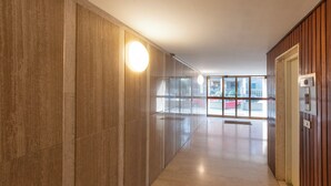 A hallway with wooden paneling and a glass door leading to a balcony. - HouSmart Treves 2 (Bologna)