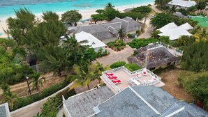 Ein Resort mit mehreren Gebäuden, einem Strand und üppiger Vegetation.