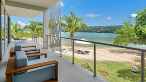 Un balcon avec des sièges et une vue sur la plage et la mer.