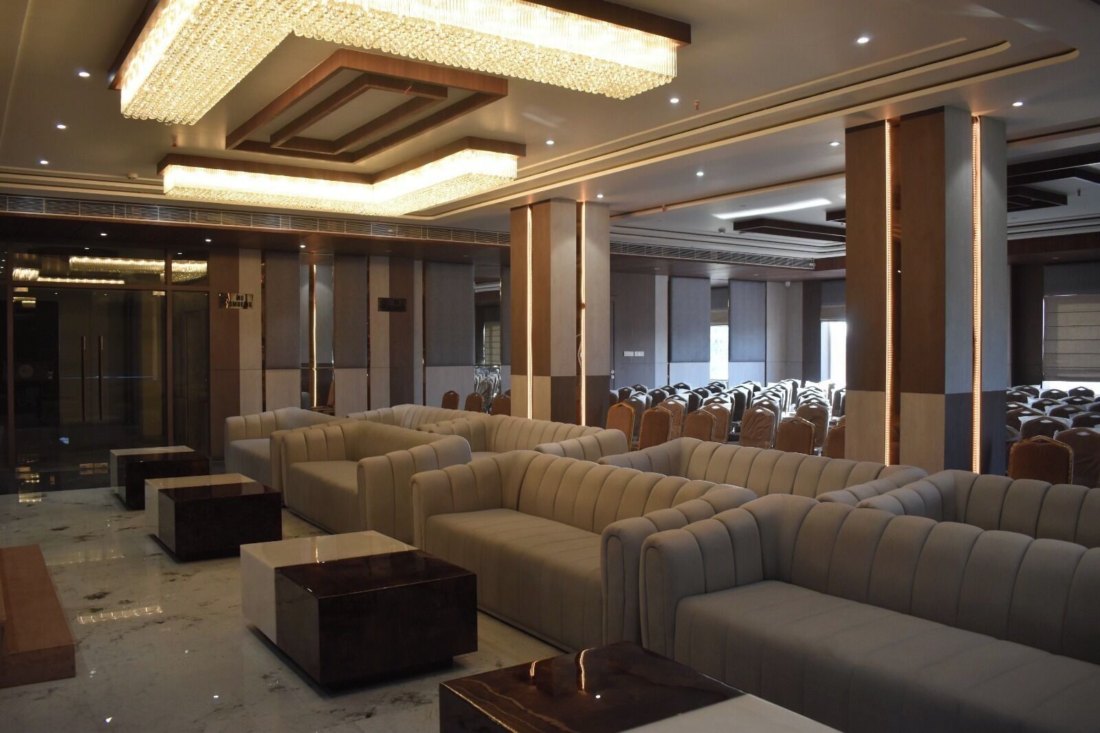 A spacious, modern lounge area with plush seating and a large chandelier.