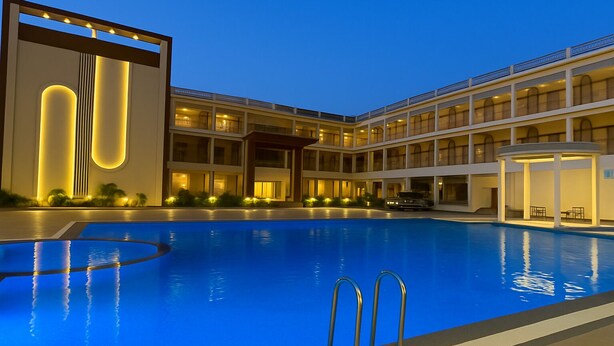 Una piscina con un edificio moderno al fondo.