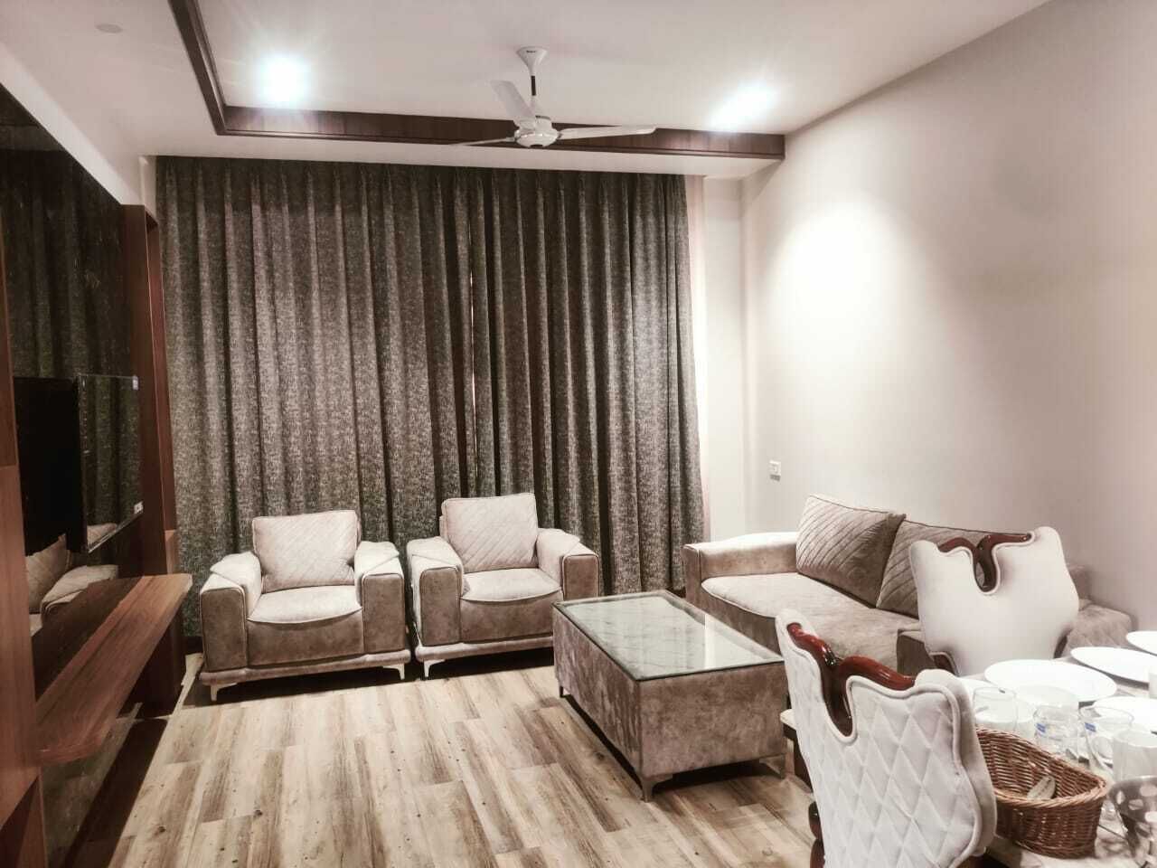 A modern living room with a sofa set, a coffee table, and a TV.
