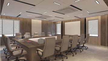 A modern conference room with a long table, multiple chairs, and a large screen.