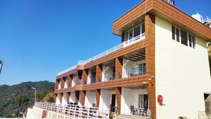 A modern building with a wooden facade and multiple balconies. - Dhurva Hotel and Resort (Lansdowne)