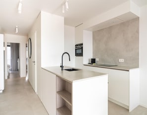 A modern kitchen with a central island, a built-in oven, and a coffee machine. - Flat at Blankenberge Marina With Terrace (Blankenberge)