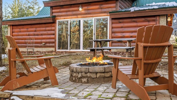 A log cabin with a fire pit, two Adirondack chairs, and a picnic table. - Dog Friendly! Private Indoor Pool, Hot Tub, GameRoom, Firepit & Free Passes. (Sevierville)