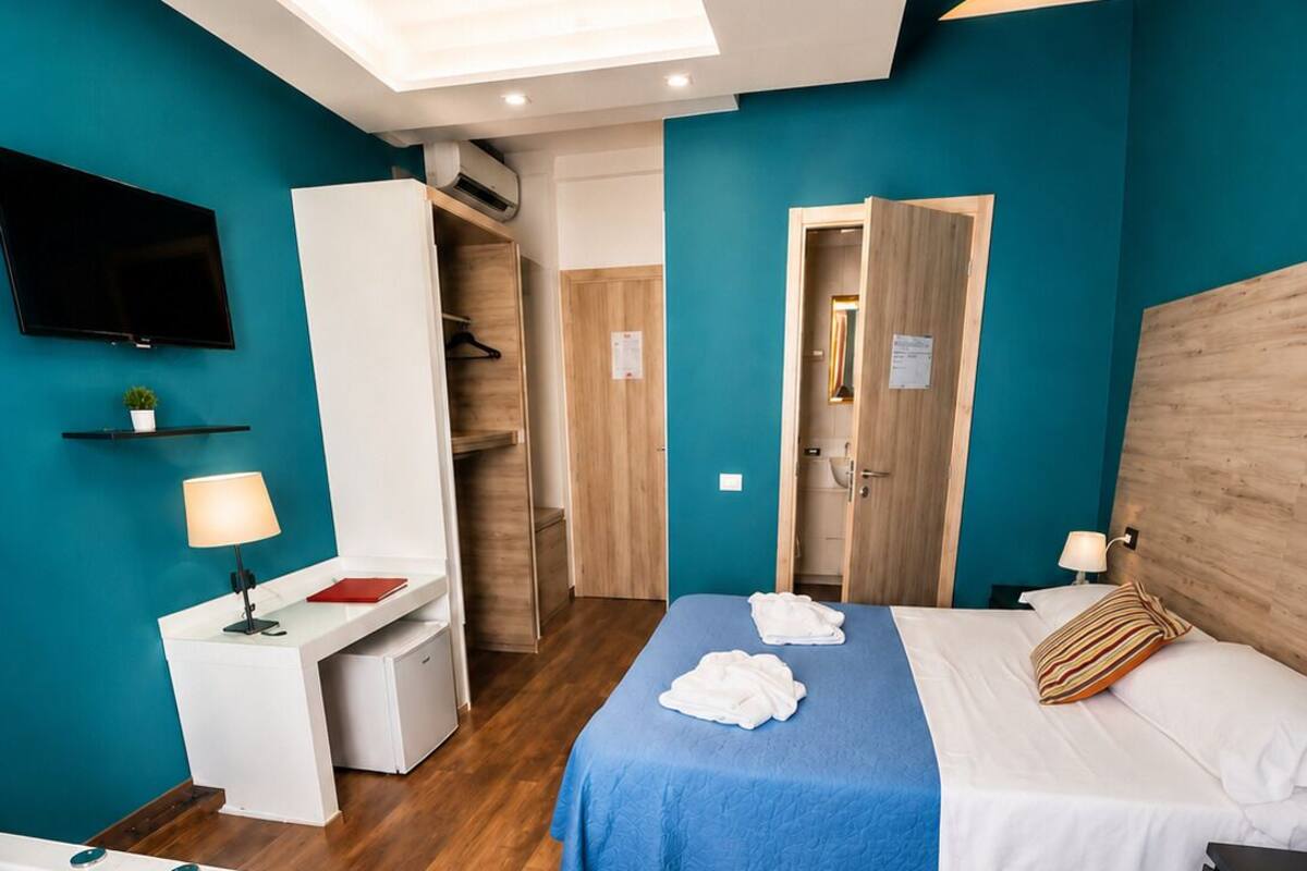 Une chambre d’hôtel équipée d’un lit, d’un bureau, d’une télévision, d’une salle de bain et d’un jacuzzi.