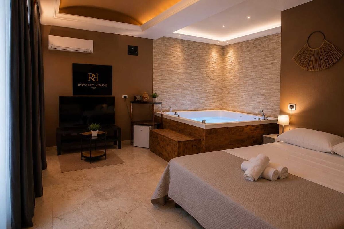 Une chambre d’hôtel avec un grand lit, une télévision, un petit bureau, une baignoire et une pancarte indiquant « CHAMBRES DE LUXE ».