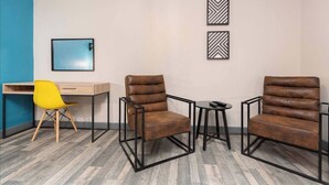 A room with two leather armchairs, a yellow chair, a small table with a remote, and a desk with a chair. - Pine Studio Apartment- Your Own Quiet Space! (Blackpool)