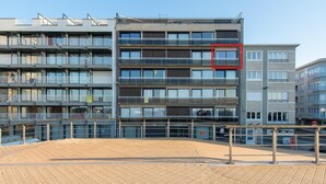 Un edificio de varios pisos con balcones y entrada a nivel de calle.