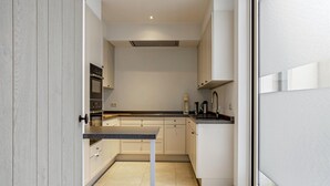 A modern kitchen with white cabinets, a black countertop, and a built-in oven. - Apartment in Blankenberge Near Sea Dyke (Blankenberge)