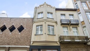 A corner building with a garage door, a bay window, and a balcony. - Apartment in Blankenberge Near Sea Dyke (Blankenberge)