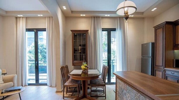 A dining area with a round table, chairs, and a cabinet.